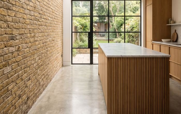 Illustration: a kitchen extension with an exposed brick wall, rooflight and crittall doors to the garden.